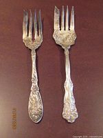 Both silver-plate serving forks side by side showing size and pattern