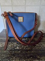 Front view of blue Dooney & Bourke crossbody bag with strap