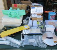 Assorted packaged home goods and hardware spread on table