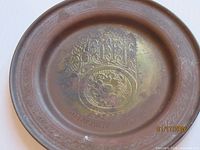 Front of brass plate showing Hamsa engraving and inscription