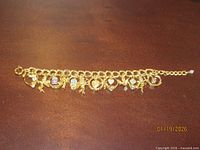 Full view of gold-tone Kirks Folly charm bracelet with multiple charms