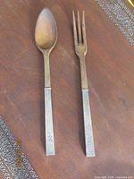Salad spoon and fork side by side displaying materials and monogram