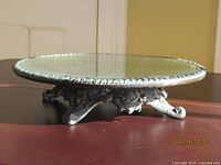 side view showing mirrored top and three-footed ornate base