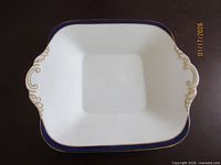 Top view showing full plate shape, cobalt rim, gold scroll handles