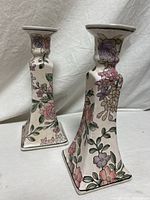 Both candle holders front three-quarter view showing floral design