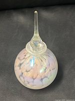 Full view of perfume bottle and stopper on black background