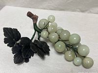 Full view of grape cluster, showing spheres, leaves, stem