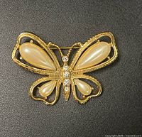 Front view of gold tone butterfly brooch