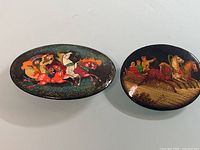 Both oval lacquer brooches front view
