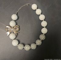 Full view of necklace showcasing bead pattern and bow