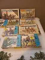 Front view of seven boxed figure sets