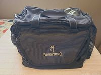 Front view of Browning tackle bag showing logo, mesh pocket and carry handles
