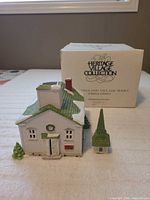 Front view of porcelain church, detached steeple, original box in background