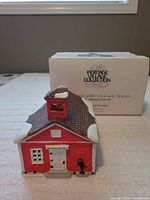 Front view of porcelain schoolhouse with box in background
