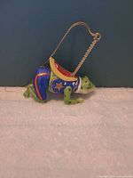 Full side view of frog ornament showing saddle and hanger