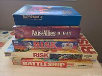 Stack of five board game boxes showing titles and wear