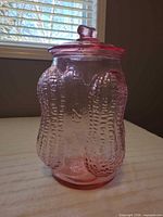 Full view of pink glass Planters peanut jar with lid