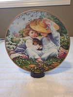 Front view of plate showing children, puppy, floral scene, gold trim