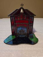 Front view showing stained glass firehouse, bell, weather vane and multicolor base