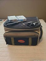 Tackle Logic bag with two Sufix line spools, pliers, forceps, scissors on top
