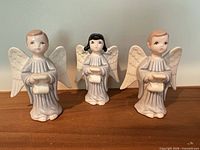 Front view of all three ceramic angel figurines