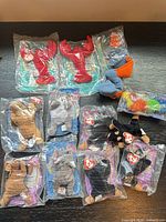 Group shot of all thirteen Teenie Beanie Babies with twelve sealed in bags and one unsealed plush