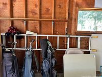 Full view of ladder stored horizontally on wall studs