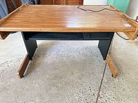 Front view of wood-grain laminate computer desk on black frame