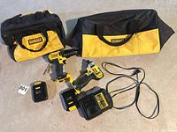 Two DeWalt drills, two batteries, charger and tool bags overview