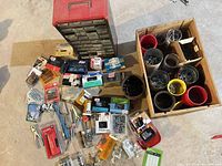 Overall lot showing storage cabinet, boxed fasteners, hand tools, crate with coffee cans and bins