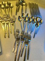 Assorted flatware pieces laid out showing pattern and quantity