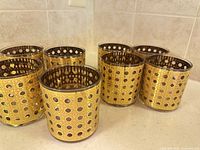 Eight Culver Cannella Executive gold overlay cocktail glasses grouped on countertop