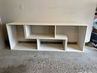 Front view of fully assembled L-shaped shelving unit showing size and cubby layout