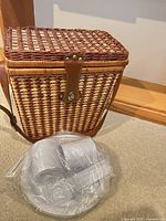 Overall view of wicker picnic basket with wrapped dish set
