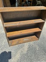 Front view showing three fixed shelves and brown finish