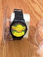Front view of watch showing holographic Yoda dial on stand