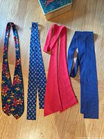 Four ascot cravats laid out flat showing full designs