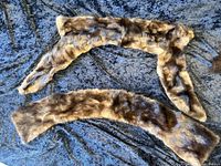 Both brown fur collars laid flat on textured surface