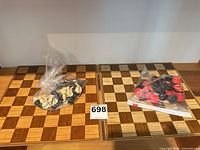 Two wooden boards with bagged chess and checker pieces
