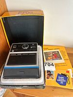 Camera seated in open original box with manual beside