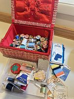 Open sewing box showing contents—threads, notions, tray, patches, chalks