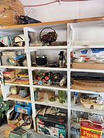 Full shelving unit with glassware, books, small appliances, faux fruit