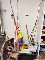 Overall lot showing skis, poles, fishing rods, bins, wire baskets and storage tote