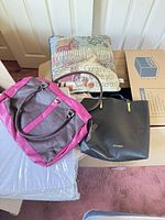Two handbags, tapestry pillow, packaged pillow partially visible