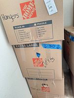 Stacked Home Depot boxes labeled hangers and clothes