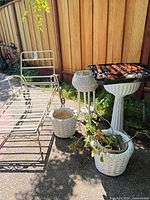 Chaise frame, three planters, pedestal birdbath with grill grate visible