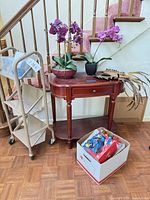 Overall lot showing console table, rolling cart, orchids, palm accent, ornament box