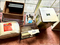 group shot showing basket, binders, sealed bedding, dish rack, tool tote, boxed beverage dispenser