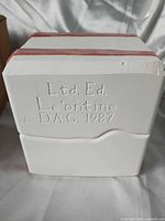 Embossed side of white two-part mold showing maker and year