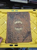 Front cover showing gilt title and ornate embossing, wear visible